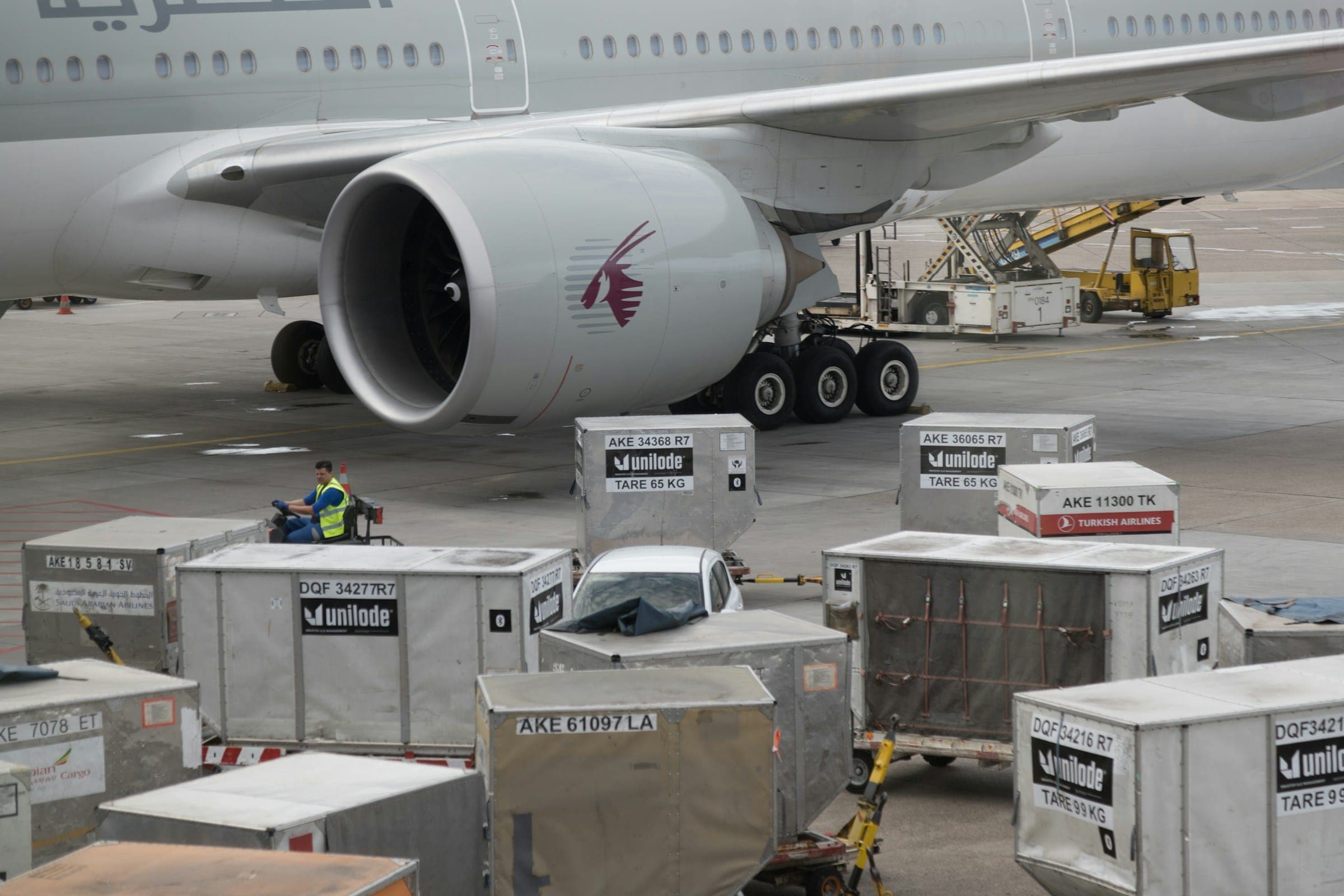 Air cargo containers staged beside a wide-body aircraft