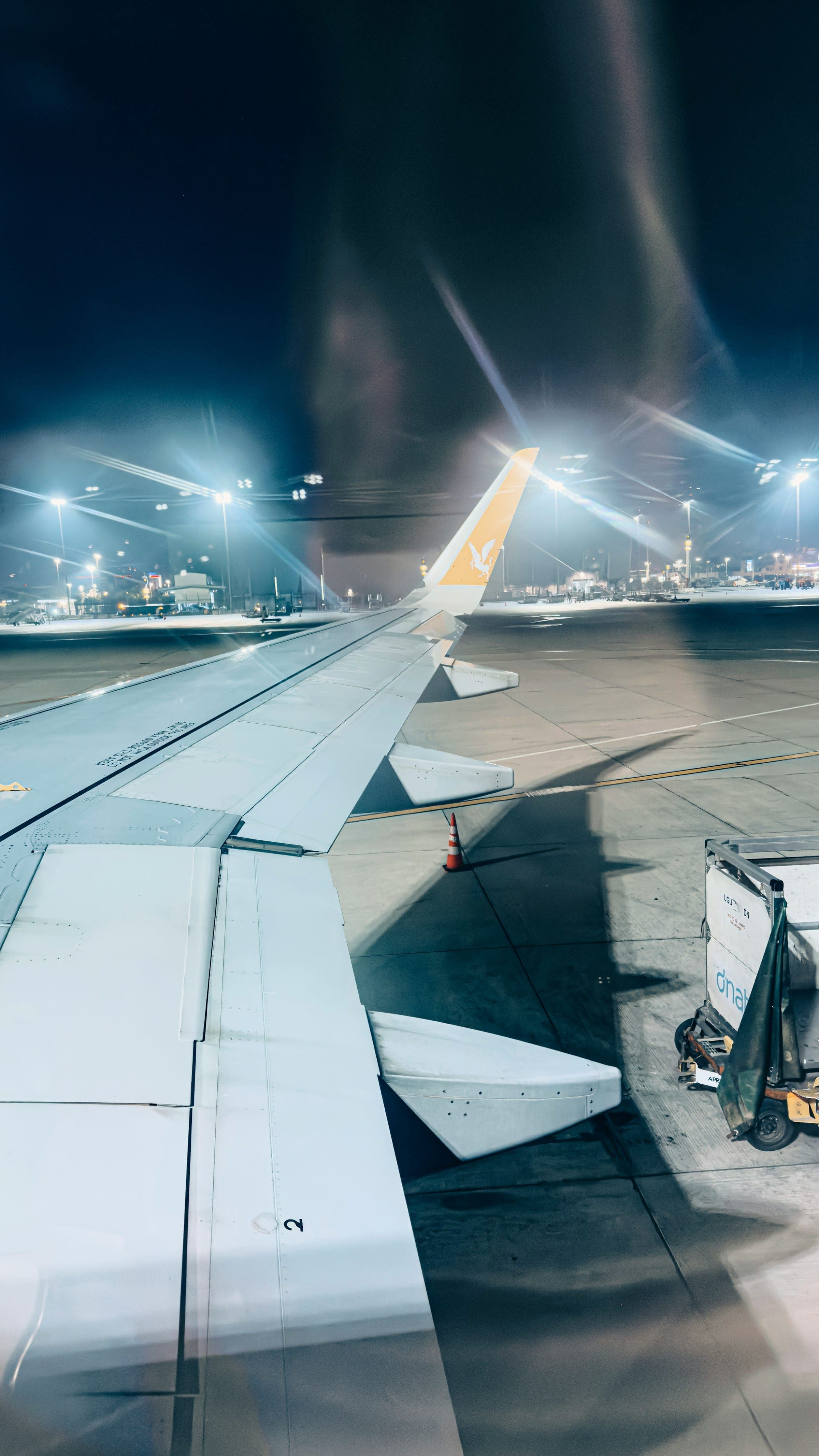 Aircraft wing on an airport apron at night